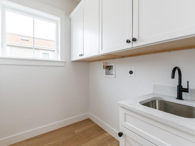 clothes washing area with sink, cabinets, hookup for an electric dryer, light hardwood / wood-style flooring, and hookup for a washing machine