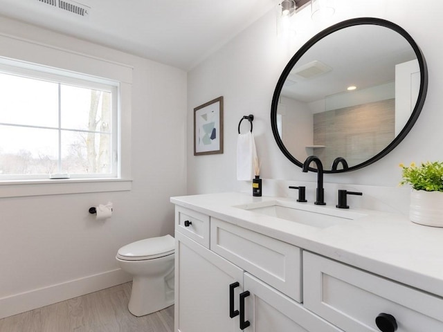 bathroom with hardwood / wood-style floors, vanity, and toilet