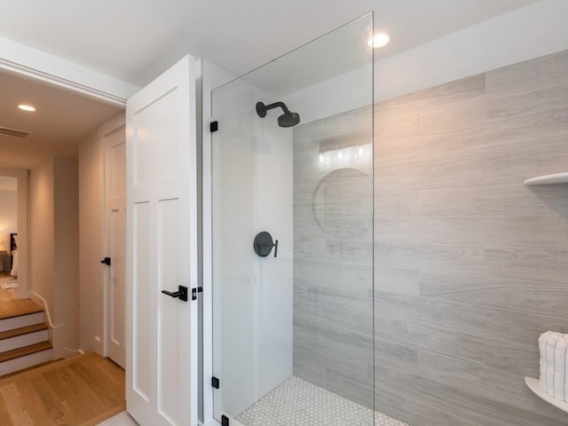 bathroom featuring hardwood / wood-style floors and a tile shower