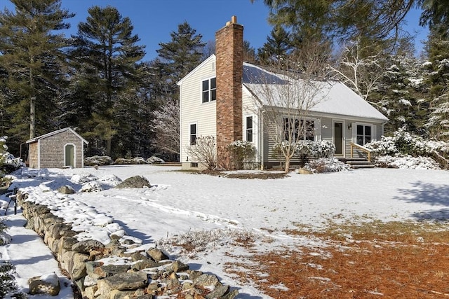 snow covered property with a shed