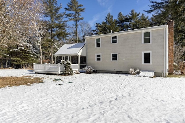 snow covered house with a sunroom