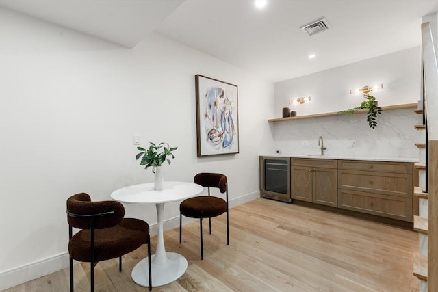 8 Holly Ave Unit 1, Cambridge, MA 02138 - dining area with bar with sink, wine cooler, baseboards, light wood finished floors, and recessed lighting