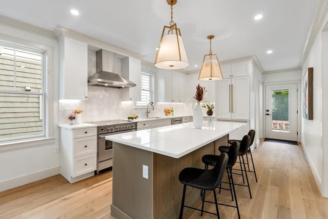 8 Holly Ave Unit 1, Cambridge, MA 02138 - kitchen featuring high end range, wall chimney exhaust hood, a sink, white cabinetry, and crown molding