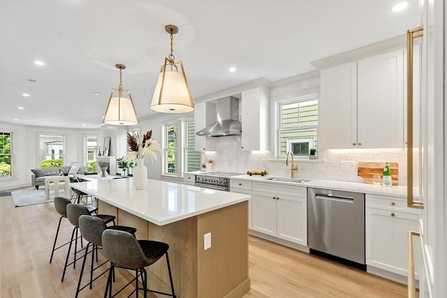 8 Holly Ave Unit 1, Cambridge, MA 02138 - kitchen with wall chimney range hood, appliances with stainless steel finishes, a sink, plenty of natural light, and recessed lighting