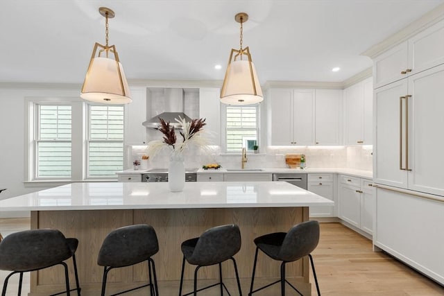 8 Holly Ave Unit 1, Cambridge, MA 02138 - kitchen featuring wall chimney range hood, a kitchen island, decorative backsplash, a breakfast bar area, and ornamental molding