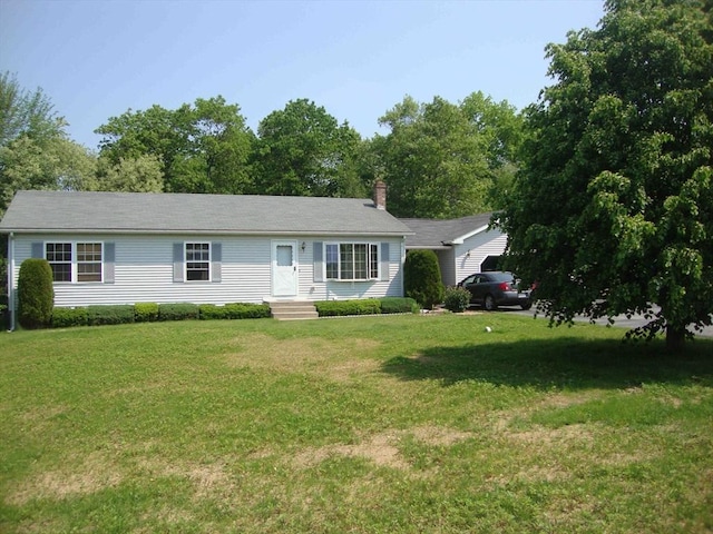 ranch-style home featuring a chimney and a front lawn
