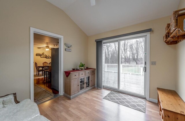 doorway to outside with light wood-style flooring, lofted ceiling, and a ceiling fan