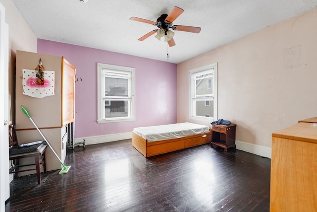 bedroom featuring ceiling fan, a textured ceiling, and dark wood-type flooring