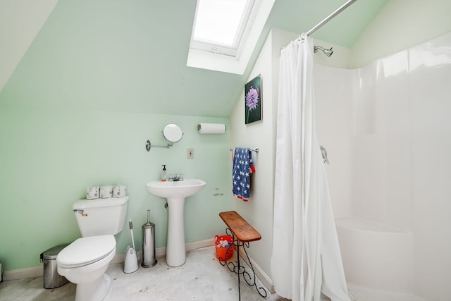 bathroom featuring a shower with curtain, vaulted ceiling with skylight, and toilet