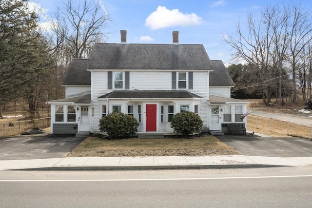 view of front of house with aphalt driveway, entry steps, a shingled roof, and fence