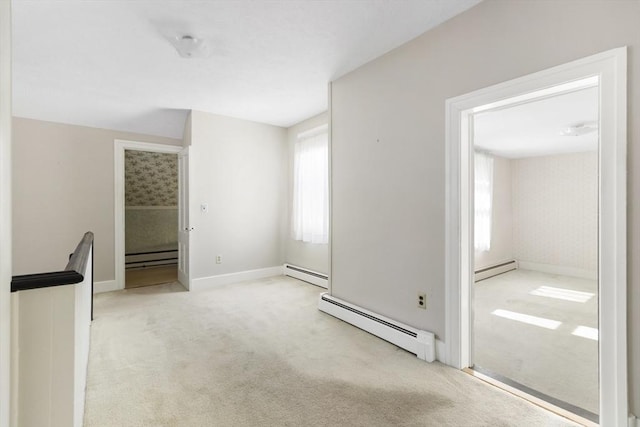 carpeted empty room with a healthy amount of sunlight and a baseboard heating unit