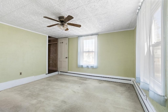 carpeted empty room with a ceiling fan, baseboard heating, and ornamental molding