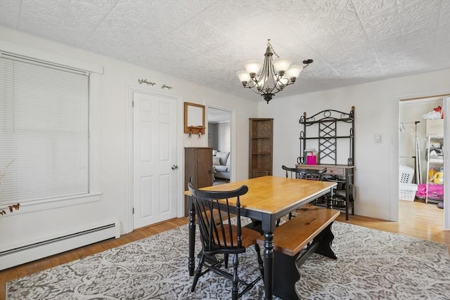 dining area featuring light wood-style flooring, a baseboard radiator, an ornate ceiling, and a chandelier