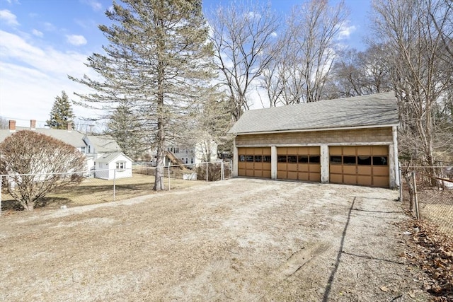 detached garage featuring fence