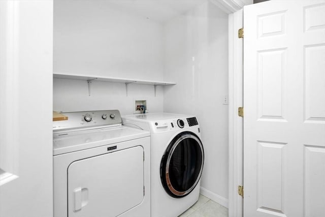 laundry area with washing machine and dryer and light tile patterned flooring