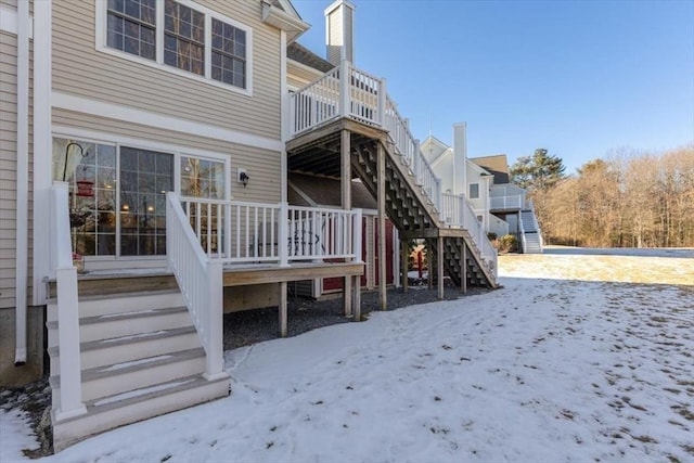 snow covered house featuring a deck