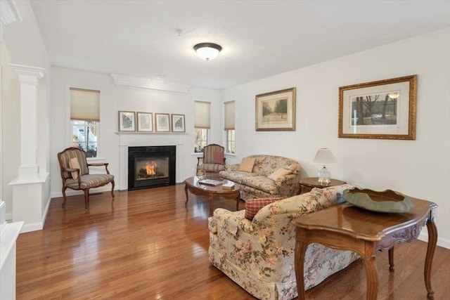 living room with decorative columns and hardwood / wood-style floors