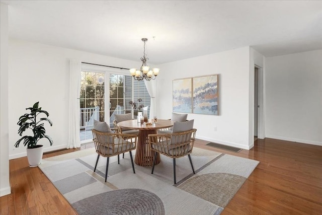 dining area with an inviting chandelier and wood-type flooring