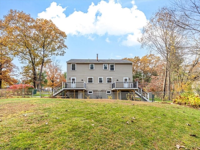 back of property featuring a wooden deck and a lawn