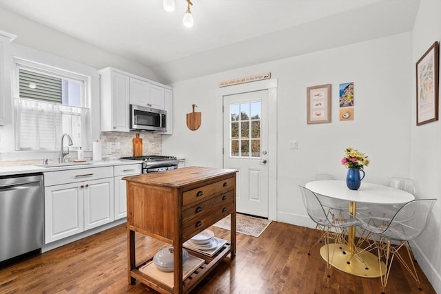 kitchen with white cabinetry, stainless steel appliances, sink, and tasteful backsplash