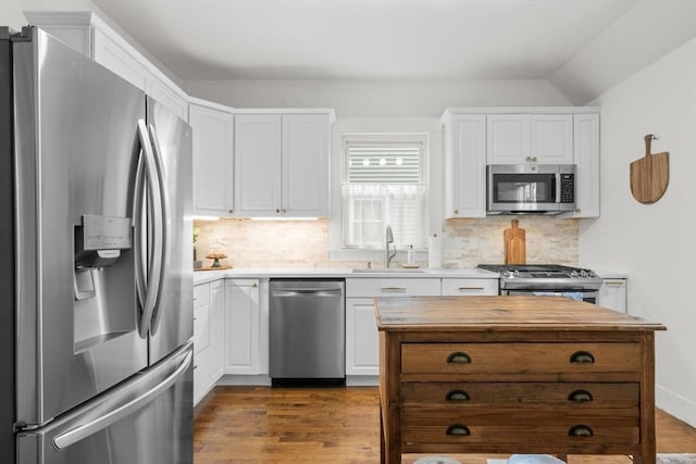 kitchen with stainless steel appliances, sink, decorative backsplash, and white cabinets