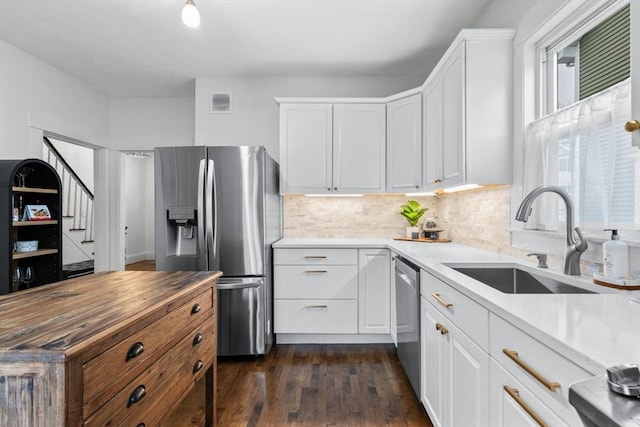 kitchen with stainless steel appliances, white cabinetry, and sink