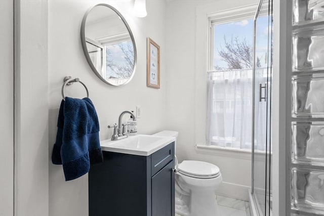 bathroom featuring a shower with door, vanity, and toilet