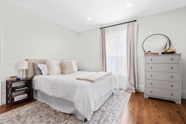 bedroom with dark hardwood / wood-style flooring