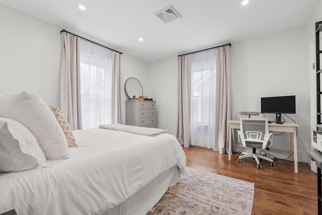 bedroom featuring dark hardwood / wood-style flooring and multiple windows