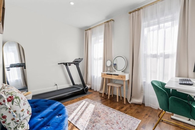 exercise area with a healthy amount of sunlight and dark hardwood / wood-style flooring