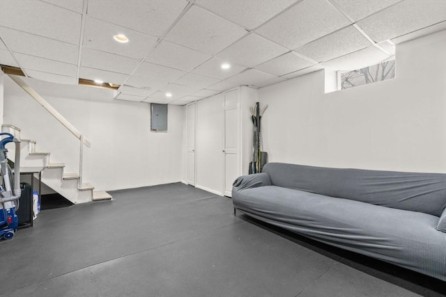 basement featuring a drop ceiling and electric panel