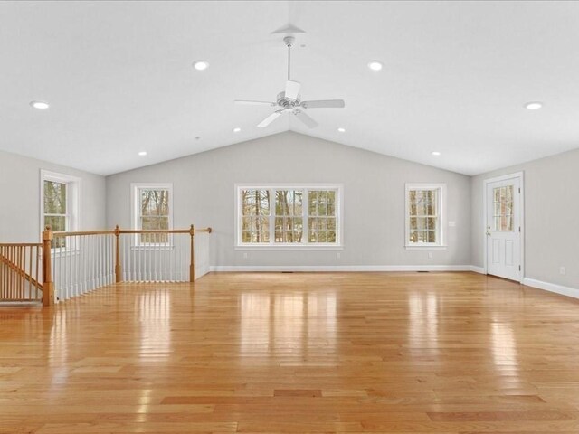 unfurnished living room featuring light wood finished floors, baseboards, vaulted ceiling, and recessed lighting