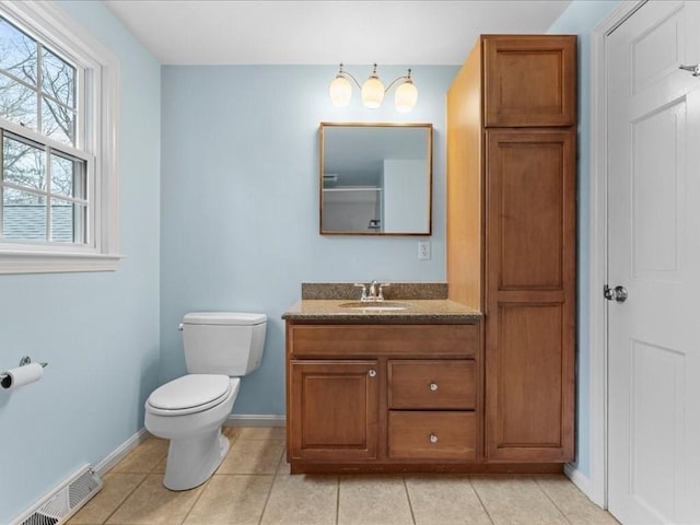 bathroom with visible vents, toilet, vanity, tile patterned flooring, and baseboards