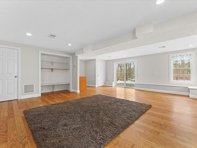 unfurnished living room featuring light wood finished floors, baseboards, visible vents, and recessed lighting