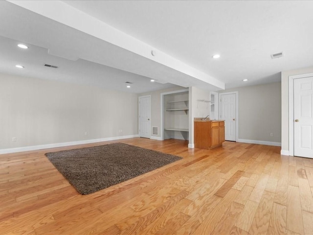 unfurnished living room with light wood-type flooring, visible vents, baseboards, and recessed lighting