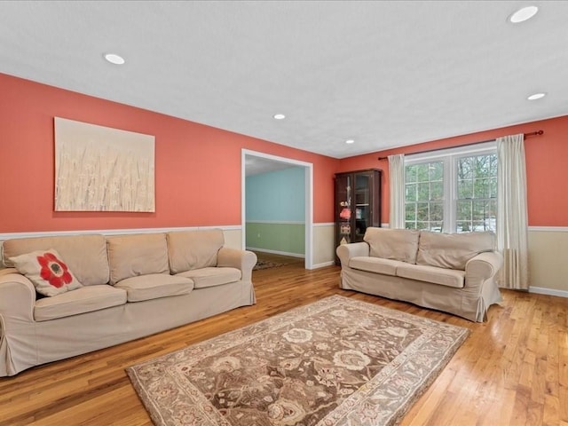 living area with baseboards, wood finished floors, and recessed lighting