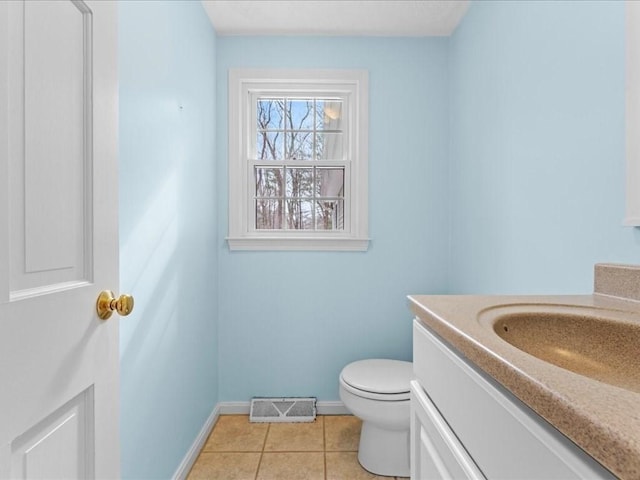 half bath featuring toilet, vanity, baseboards, visible vents, and tile patterned floors