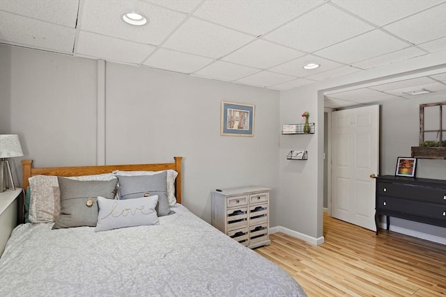 bedroom with a paneled ceiling and wood-type flooring