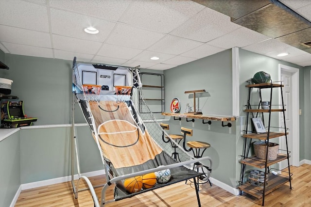 interior space with a drop ceiling and hardwood / wood-style floors