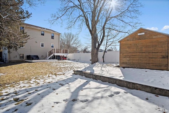 yard layered in snow with a storage unit