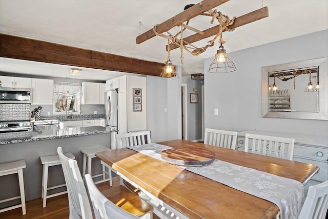 dining room with beamed ceiling and dark hardwood / wood-style floors