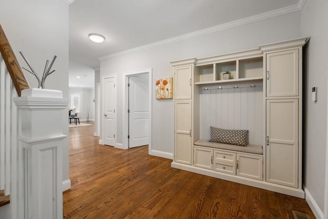 mudroom with dark wood-style floors, crown molding, and baseboards