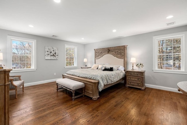 bedroom featuring dark wood finished floors, visible vents, and baseboards