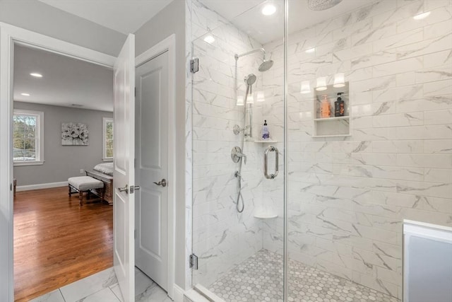 ensuite bathroom with a marble finish shower, baseboards, connected bathroom, wood finished floors, and recessed lighting