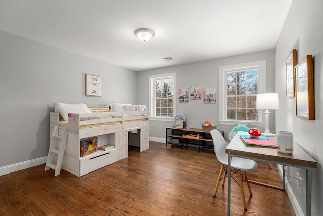 bedroom with wood finished floors, visible vents, and baseboards