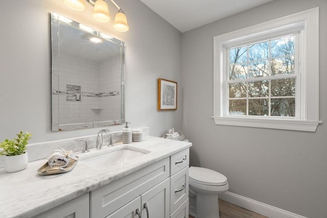 full bathroom with baseboards, toilet, wood finished floors, walk in shower, and vanity