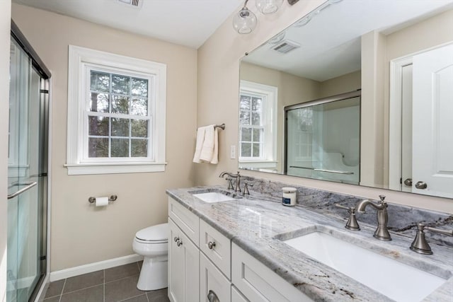 bathroom with a sink, a shower stall, toilet, and tile patterned floors