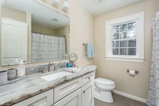 bathroom with tile patterned flooring, baseboards, vanity, and toilet