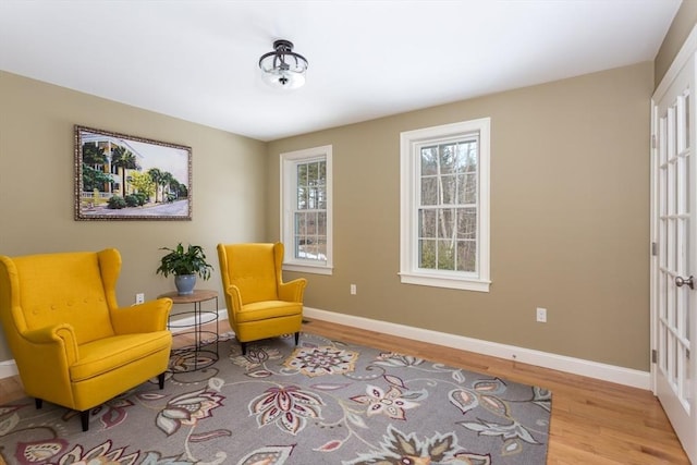 living area with baseboards and wood finished floors