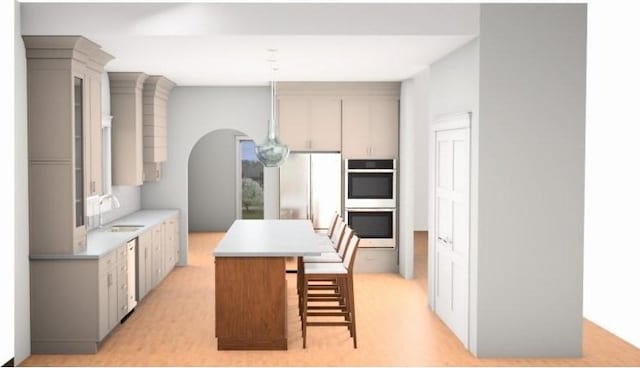 kitchen featuring a breakfast bar, stainless steel appliances, sink, decorative light fixtures, and a kitchen island